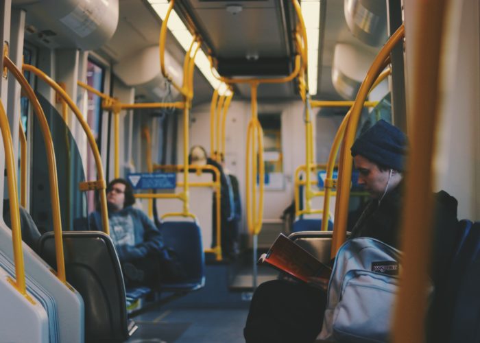 Person reading on public bus. Credit: Pexels